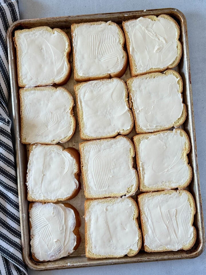 Cream cheese mixture spread on every piece of bread on sheet pan.
