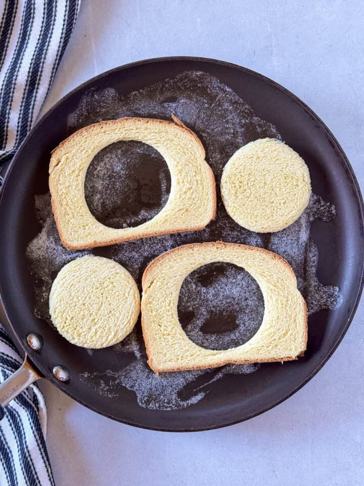 Bread and centers cut out added to skillet with melted butter.