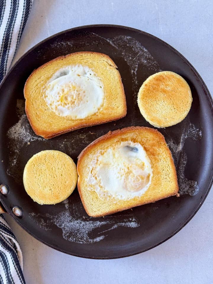 Egg in a hole flipped over on skillet.