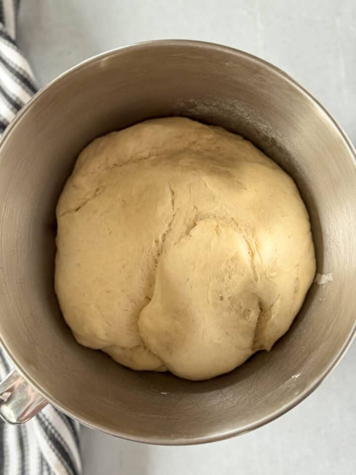 Risen bread dough in mixing bowl.