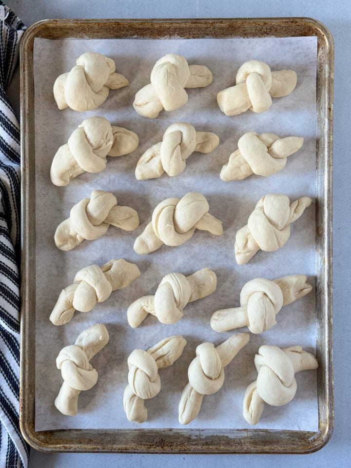 Risen garlic knots on sheet pan.