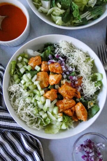 Top view of buffalo chicken salad in white salad bowl.